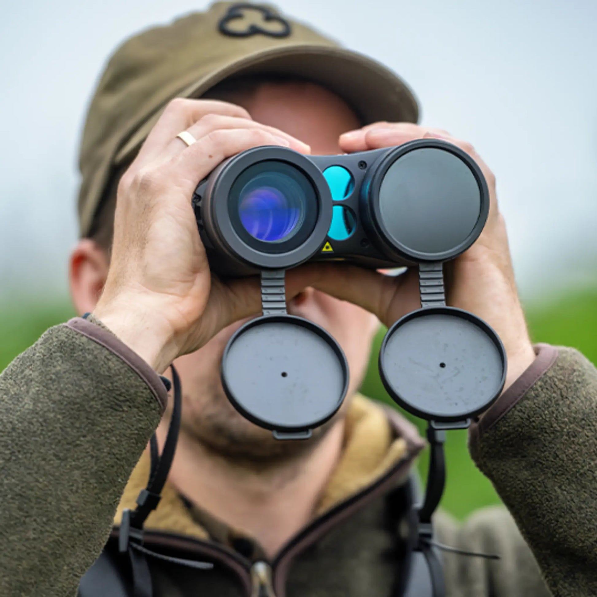 Client holding the InfiRay Gemini GEH50R thermal imaging binoculars, showcasing the dual lenses, control buttons, and ergonomic design.