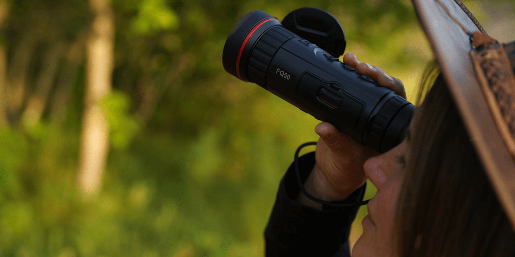 Woman holding a HikMicro Falcon FQ50 Thermal Monocular while observing nature, showcasing the advanced infrared imaging capabilities of the hikmicro fq50.