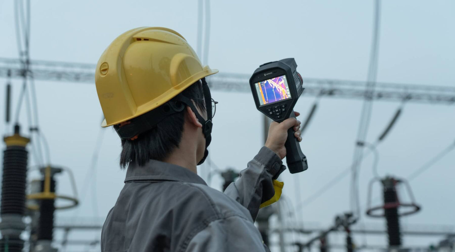 HikMicro G61 Handheld Thermal Imager Camera being used to measure temperature on electrical distribution lines.
