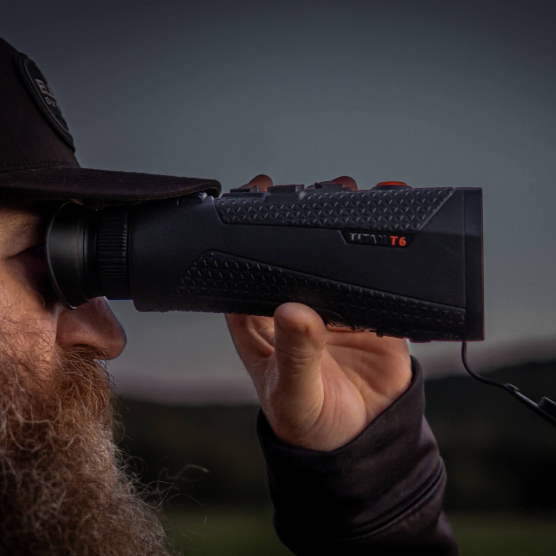 RIX Titan T6 Thermal Monocular held by a man in a close-up shot during low-light conditions, emphasizing its superior <20mK thermal sensitivity and high-contrast OLED display for midnight tracking.